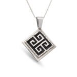 Dije Greca confeccionado en plata 925 con detalles de plata envejecida, diseño cuadrado con greca prehispánica en relieve.